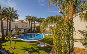 Bazén v ubytování Adosado con jardin y piscina Palm Beach 86 ALBERT VILLAS nebo v jeho okolí