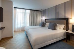 um quarto de hotel com duas camas e uma janela em Hyatt Regency Hesperia Madrid em Madrid