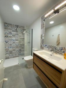 a bathroom with a sink and a toilet and a mirror at Alojamiento Turístico Casa Elvira in Yecla