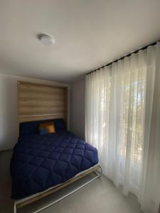 a bedroom with a blue bed and a window at Alojamiento Turístico Casa Elvira in Yecla