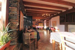 a restaurant with a table and chairs and a stone wall at Hotel Rural La Encantada en Riaza in Becerril