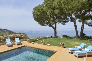a pool with chairs and a view of the ocean at Villa Can Miquelet Deia in Deia