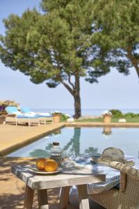 Villa Can Miquelet Deia في دِيّا: طاولة نزهة عليها برتقال بجوار حمام سباحة