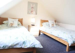 a bedroom with two beds and a night stand at Byefield Lodge in Great Malvern