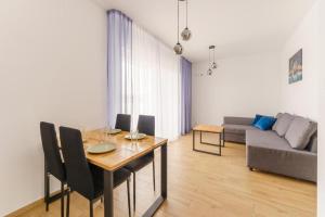 a living room with a table and a couch at Apartament Berlinek in Grzybowo