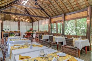 uma sala de jantar com mesas e cadeiras brancas em Aldeia da Mata Ecolodge em Serra Grande