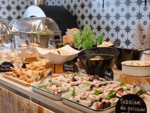 un buffet avec de nombreux types de nourriture sur une table dans l'établissement Mercure Peyragudes Loudenvielle Pyrénées, à Loudenvielle