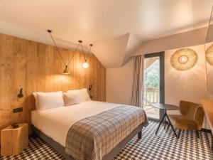 ルダンヴィエルにあるMercure Peyragudes Loudenvielle Pyrénéesのベッドとバルコニー付きのホテルルーム