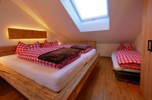 a bedroom with two beds with red and white pillows at Ferienwohnungen beim Sommermader in Nesselwang