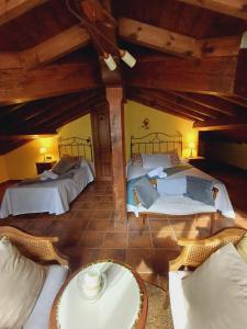 an attic room with two beds and a table at El Portal del Abuelo in Arenas de Cabrales