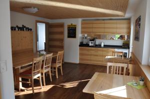eine Küche mit Holztischen und Holzschränken in der Unterkunft Gästehaus Eisenhut in Walzenhausen
