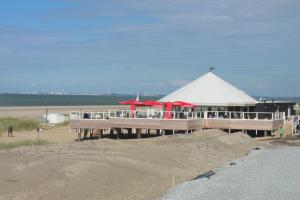 a building with red umbrellas on the beach at Kustverhuur, Park Schoneveld, Duinroos 153 in Breskens