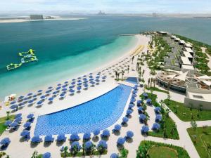 een luchtzicht op een strand met parasols en een zwembad bij Mövenpick Resort Al Marjan Island in Ras al Khaimah