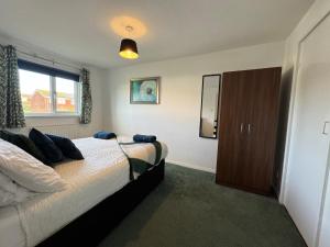 a bedroom with a bed and a window at Blackwater Terrace Witham 