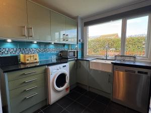 a kitchen with a washer and a washing machine in it at Blackwater Terrace Witham 