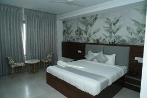 Un dormitorio con una cama grande y una mesa y sillas. en Hotel NorthInn, en Mancherāl