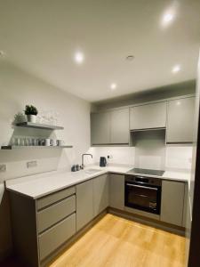 una cocina con armarios blancos y fregadero en Beautiful Penthouse In Bristol - new, en Bristol