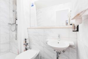bagno bianco con lavandino e servizi igienici di Gasthof Engel a Obergünzburg