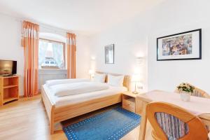 Schlafzimmer mit einem Bett, einem Schreibtisch und einem Tisch in der Unterkunft Gasthof Engel in Obergünzburg