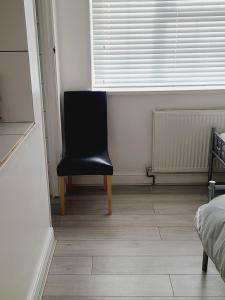 a black chair sitting in the corner of a room at QUICK STOP-GATWICK STAY, Family Room GR5 in Ifield