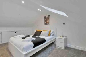 a white bedroom with a large white bed and a nightstand at 2 Bedroom City Centre Apartment with Free Parking in Gloucester
