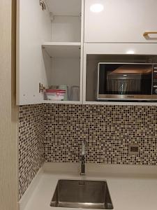 a kitchen with a sink and a microwave at dusit grand park 2 pool view in Jomtien Beach