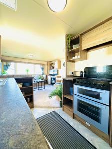 a kitchen with a stove and a living room at Dunlin Retreat in Flamborough +75 photos