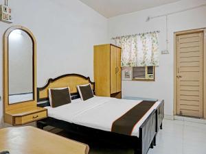 1 dormitorio con 1 cama y 1 mesa en una habitación en Thakkar Lodge, en Sāngli