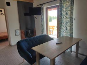 a living room with a blue couch and a table at Posiadłość Nad Zatoką in Ryn