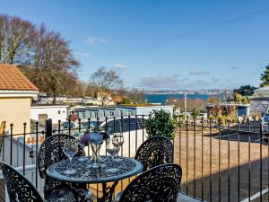 a table with wine glasses on top of a balcony at 2 Bed in Brixham 90912 in Brixham