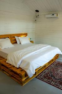 a bedroom with a large bed on a wooden platform at The Pearl Beach Resort in Canacona