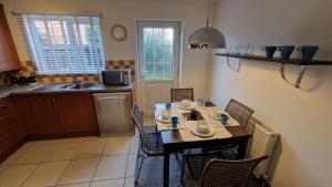 a kitchen with a table and chairs in a kitchen at 3-Bedroom Family Holiday Home in Skegness