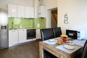 Apartman Karolina في زغرب: مطبخ مع طاولة خشبية مع كراسي سوداء