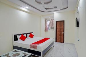 ein Schlafzimmer mit einem Bett mit roten Kissen darauf in der Unterkunft OYO Flagship Hotel Jojo In in Ghaziabad