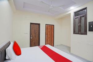 um quarto com uma cama com almofadas vermelhas em OYO Flagship Hotel Jojo In em Ghaziabad