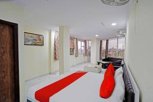 ein Schlafzimmer mit einem großen weißen Bett mit roten Kissen in der Unterkunft OYO Flagship Hotel Jojo In in Ghaziabad