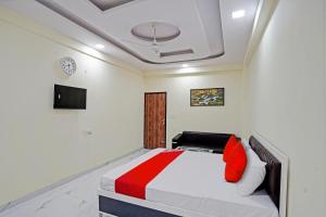 Schlafzimmer mit einem Bett mit roten und weißen Kissen in der Unterkunft OYO Flagship Hotel Jojo In in Ghaziabad