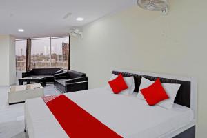 a bedroom with a red and white bed and a piano at OYO Flagship Hotel Jojo In in Ghaziabad