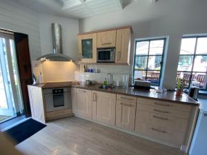 a large kitchen with wooden cabinets and appliances at Londons Cottage in Hilversum