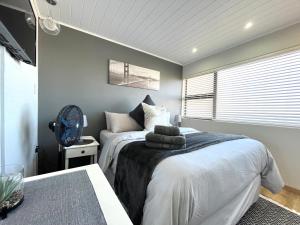 ein Schlafzimmer mit einem großen Bett und einem Fenster in der Unterkunft Coastal Hospitality - De Valle 65 in Mossel Bay