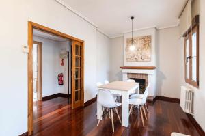 ein Esszimmer mit einem Tisch, Stühlen und einem Kamin in der Unterkunft Apartamento La Vega de Santiago 2 in Posada de Llanes