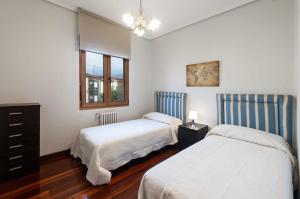 1 Schlafzimmer mit 2 Betten, einer Kommode und einem Fenster in der Unterkunft Apartamento La Vega de Santiago 2 in Posada de Llanes