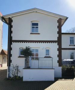 ein weißes Haus mit Balkon auf einer Straße in der Unterkunft Villa Baltica Wohnung 01 in Dahme