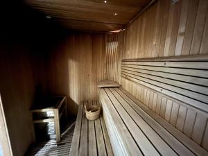 un banco de madera en una sauna con un cubo en Luxury Beachfront Studio Apartment Marjan Island en Ras al-Jaima