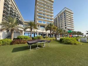 a ping pong table in a park in front of buildings at Luxury Beachfront Studio Apartment Marjan Island in Ras al Khaimah