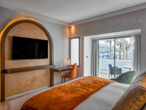 アガディールにあるSofitel Agadir Royal Bay Resortのベッドとテレビが備わるホテルルームです。