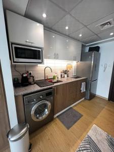 a kitchen with a washing machine and a microwave at Luxury Beachfront Studio Apartment Marjan Island in Ras al Khaimah