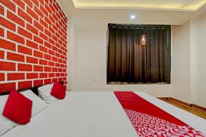 a bedroom with a brick wall and a bed with red pillows at Vachan Garden And Resort in Bhopal