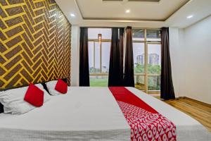 a bedroom with a bed and a large window at Vachan Garden And Resort in Bhopal