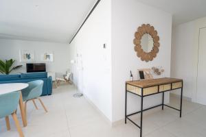 een woonkamer met een blauwe bank en een tafel bij El Sol Higueron West Apartment in Fuengirola